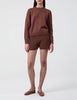 Woman wears Casasola Alba knitted cotton brown shorts with matching crewneck 