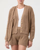 Model wearing Casasola Aurora Knitted Cotton Camel Cardigan with matching shorts and bag