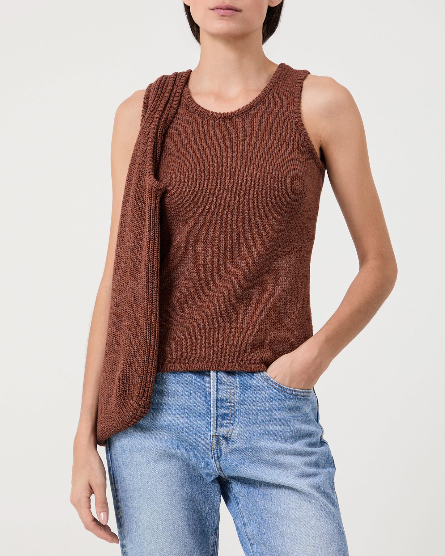 Woman wears Casasola Carolina knitted cotton brown tank top with matching bag and jeans
