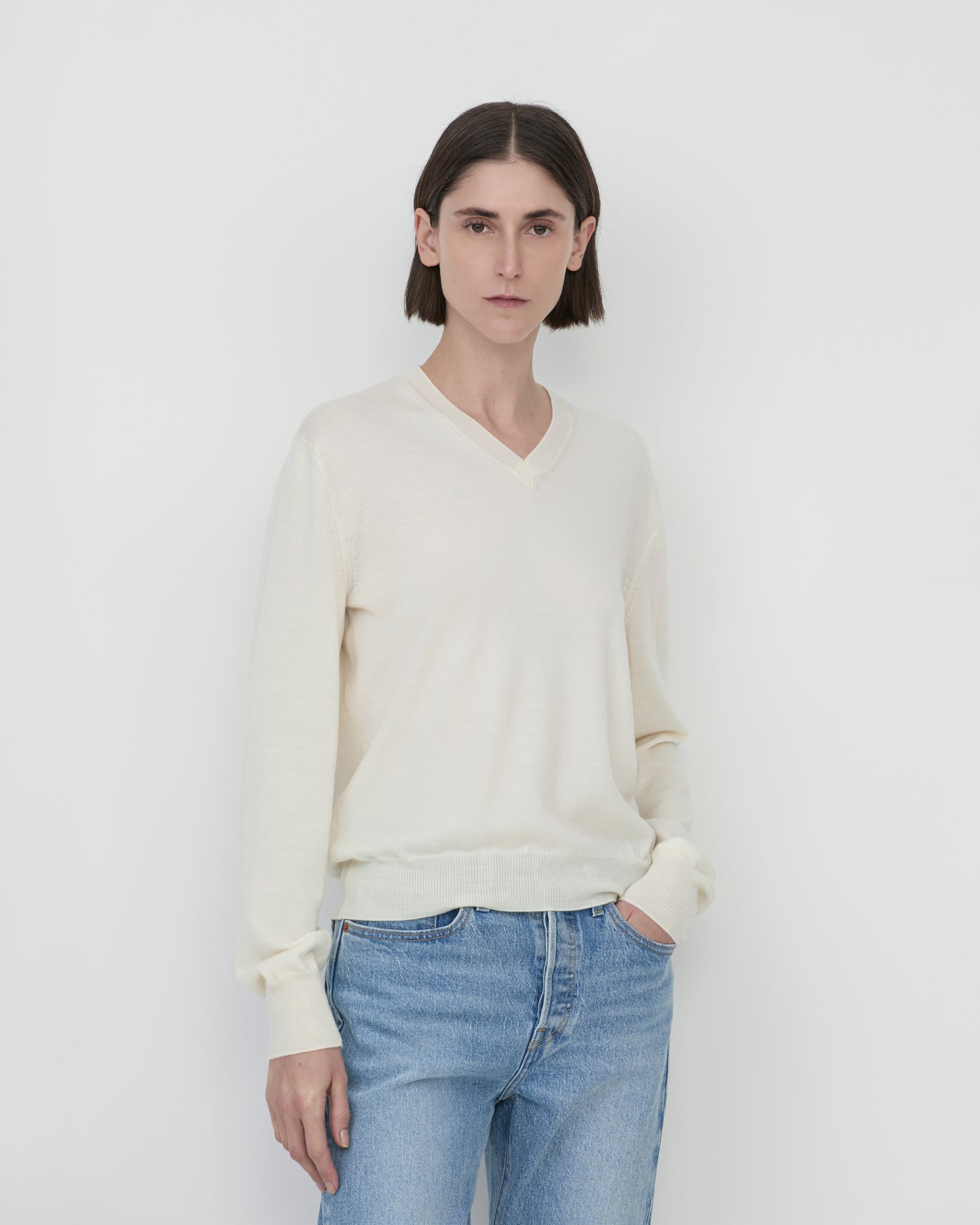 Model wearing Casasola Giada knitted wool classic v-neck sweater in Ivory - front view