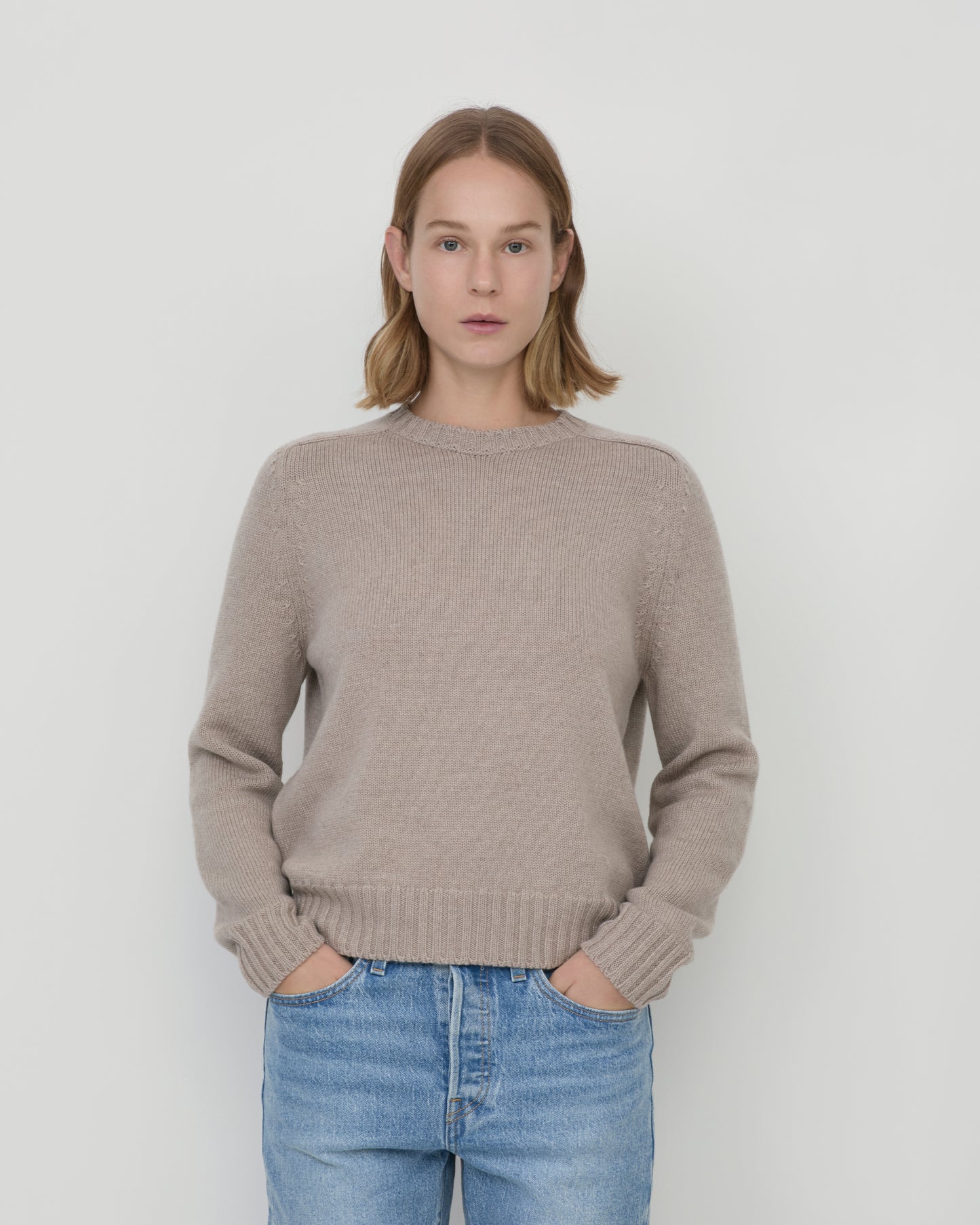 Woman wearing Casasola Mia Knitted Merino Wool Saddle Shoulder Crewneck in Beige