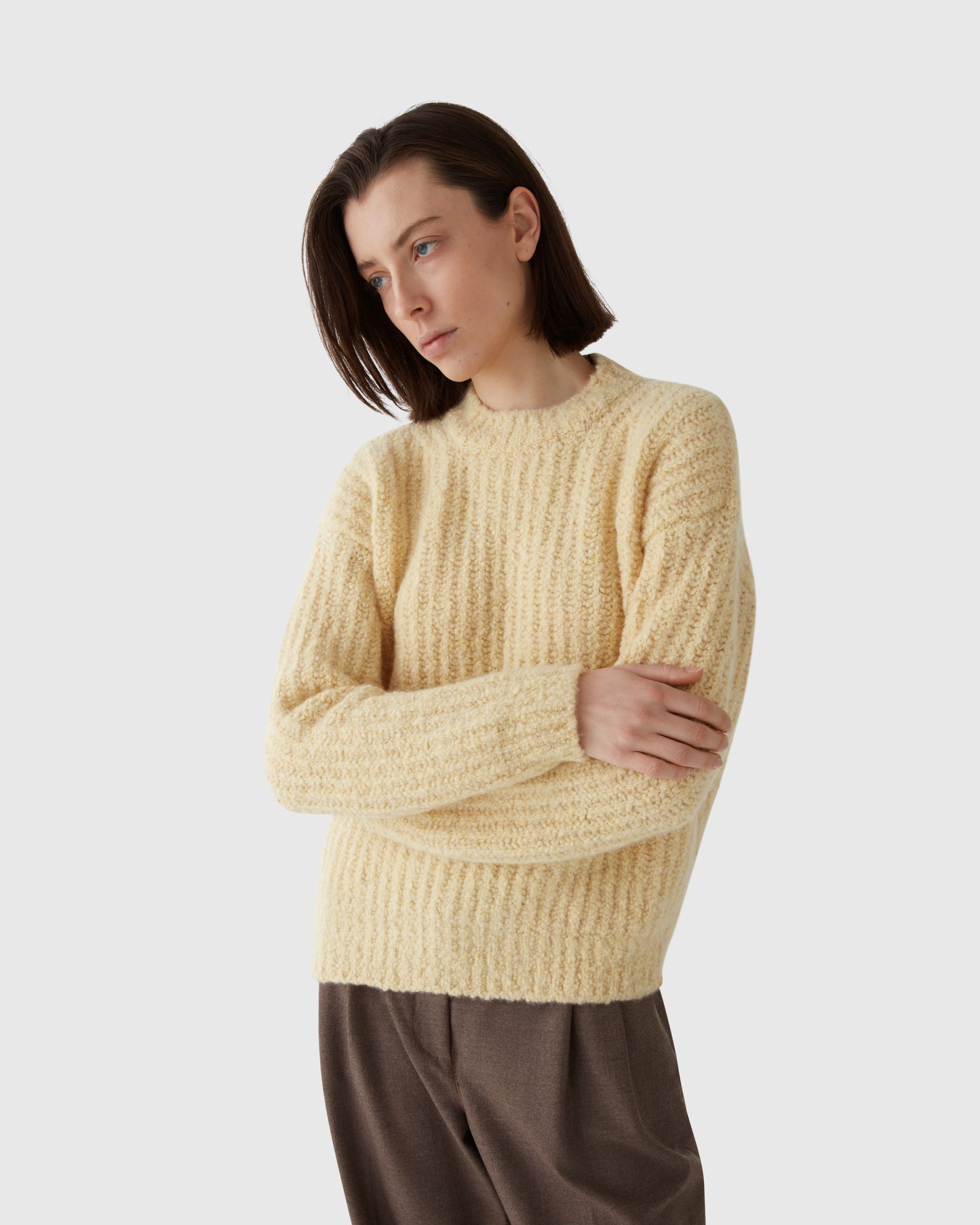 Women wearing Casasola Orso Cashmere Silk Yellow Boucle Crewneck with high-waisted trousers - Front View