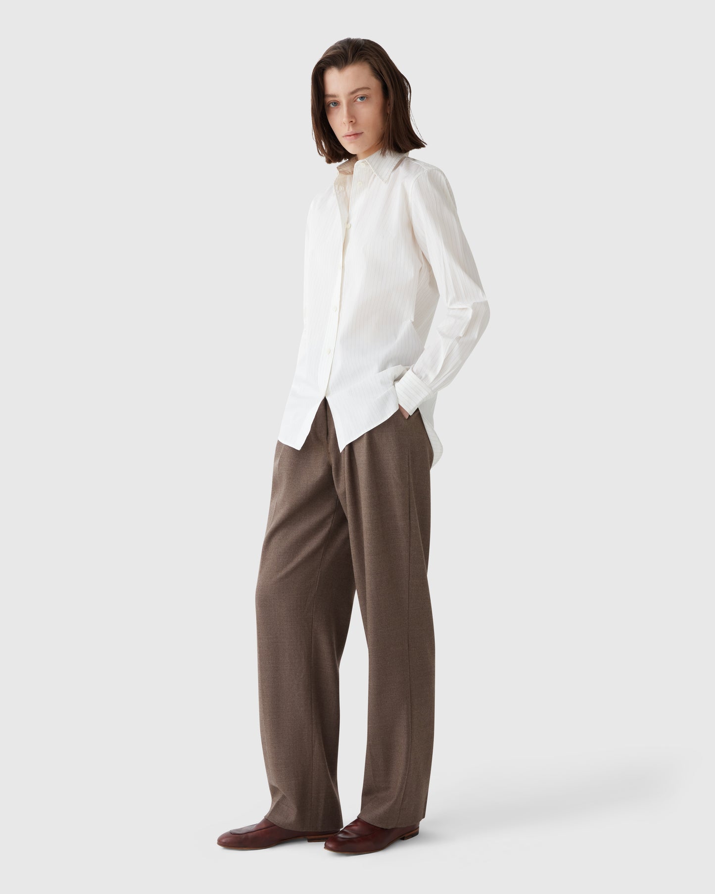 Model wearing Casasola brown flannel trousers styled with a cream shirt