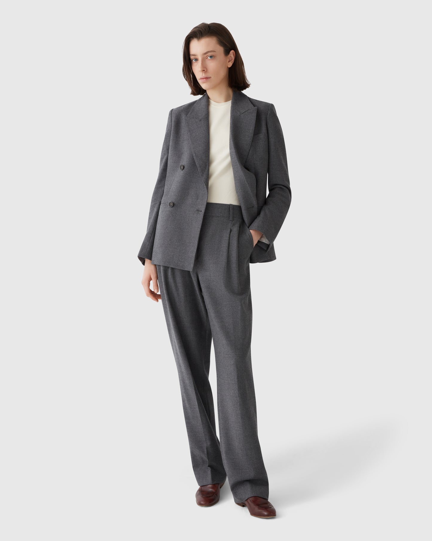 Model wearing Casasola grey Italian flannel high-waisted trousers with front pleats