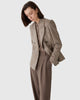 Model wearing CASASOLA 4x1 double-breasted tweed blazer with brown high-waist flannel trousers and cashmere polo, made in Italy – side view