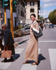 Woman walks across street in Florence Italy and wears Casasola Celina knitted cotton short-sleeve crewneck in  camel with matching midi-skirt