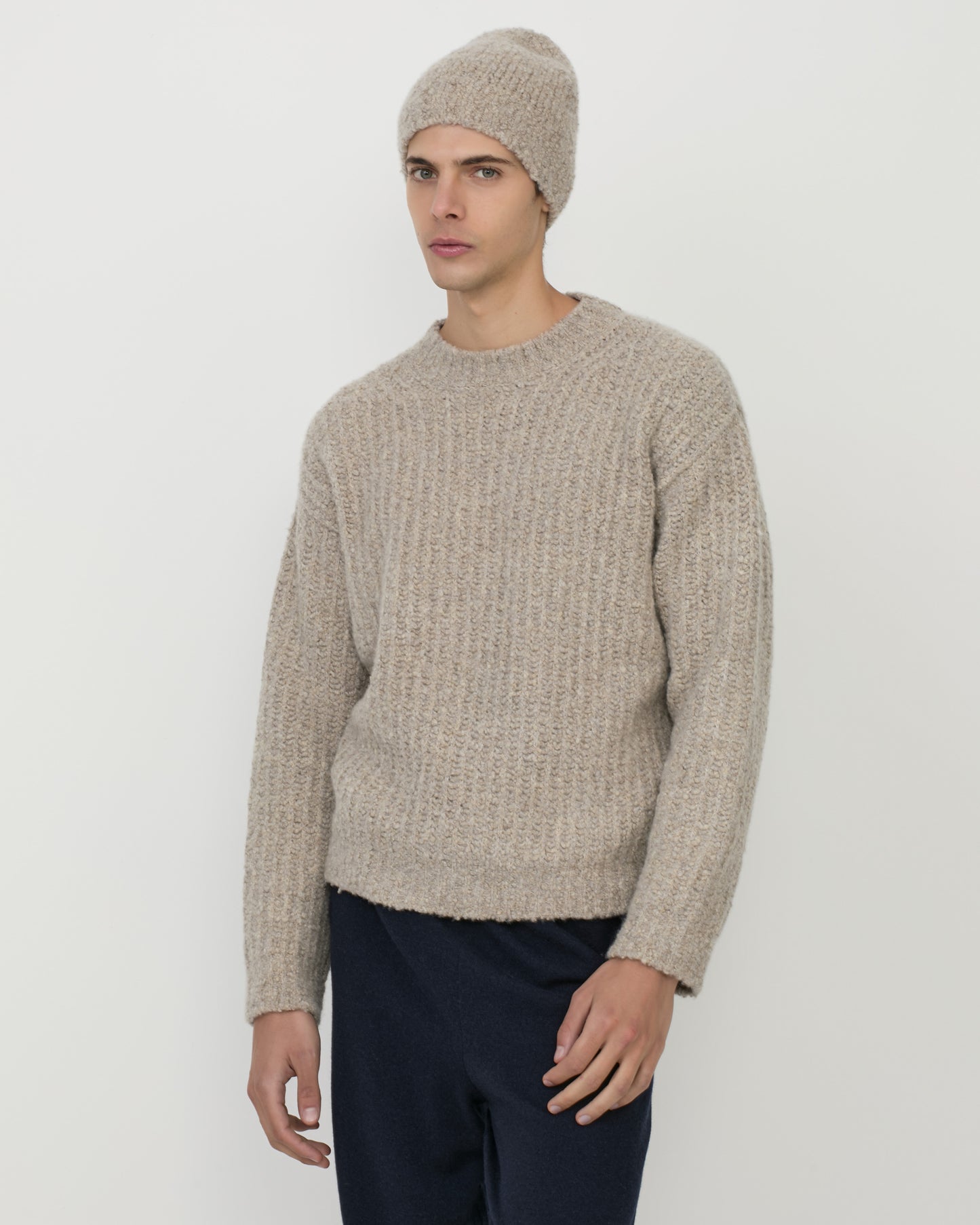 Man wearing Casasola Fedele cashmere and silk knitted boucle beanie in beige with matching crewneck sweater