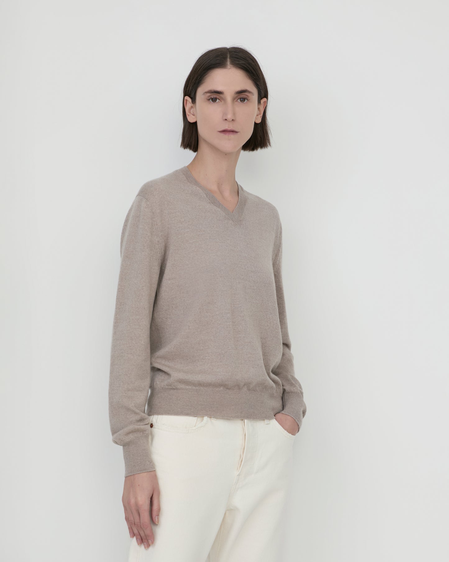 Woman wears Casasola Giada wool V-Neck Sweater in Stone - front view