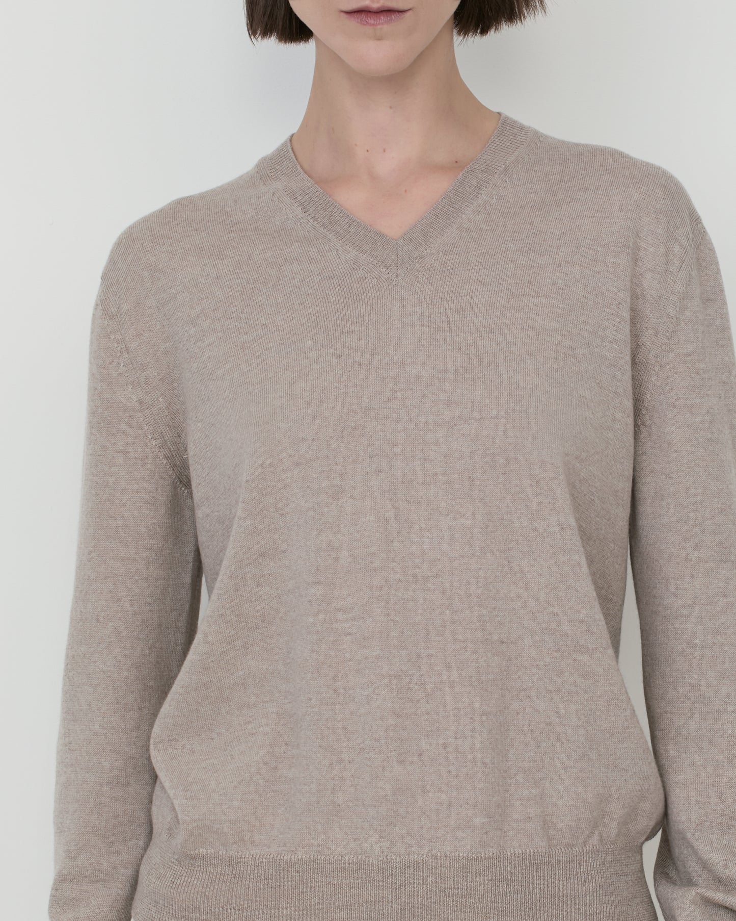 Woman wears Casasola Giada wool V-Neck Sweater in Stone - detail view