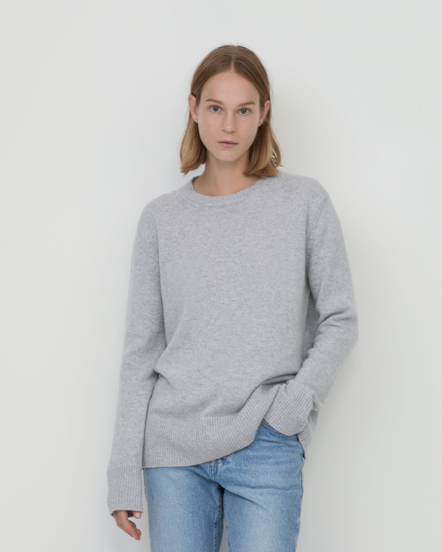 Woman wears Casasola Maria knitted cashmere oversized crewneck sweater in grey - front view