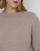 Woman wearing Casasola Mia Knitted Merino Wool Saddle Shoulder Crewneck in Beige - detail view