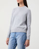 Woman wears Casasola Mia Knitted Merino Wool Saddle Shoulder Crewneck in Grey