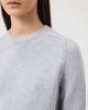 Woman wears Casasola Mia Knitted Merino Wool Saddle Shoulder Crewneck in Grey - detail view