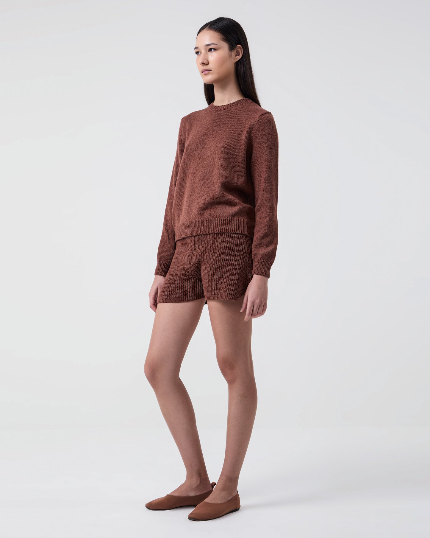 Woman wears Nina knitted cotton crewneck Brown with matching Aba shorts