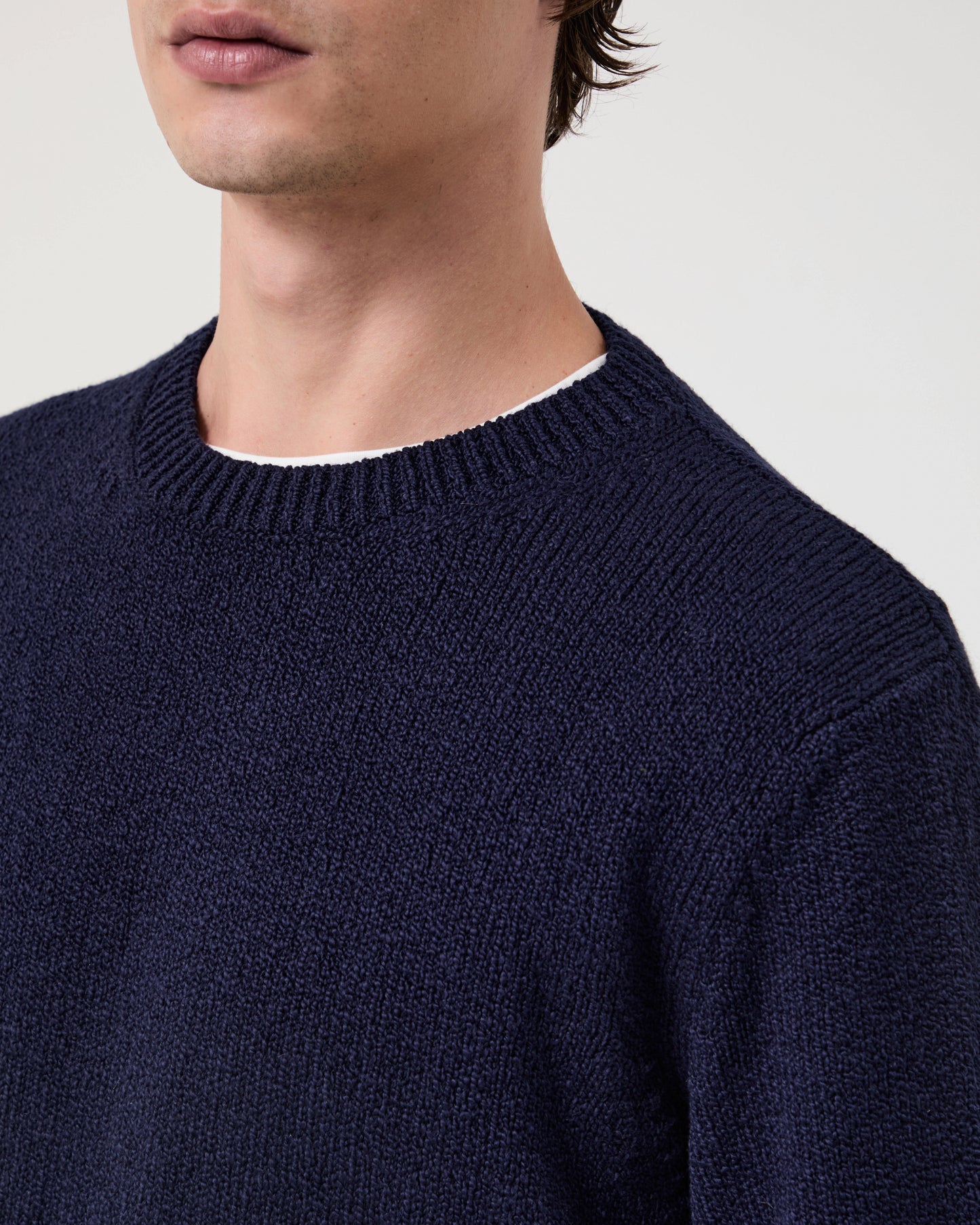 Model Wearing Casasola Nino Knitted Cotton Crewneck in Navy - Detail View