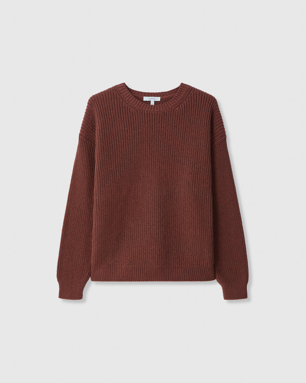 A heavyweight classic knitted cotton crewneck sweater in brown with a medium rib-stitch and finely ribbed neckline, cuffs, and hem.